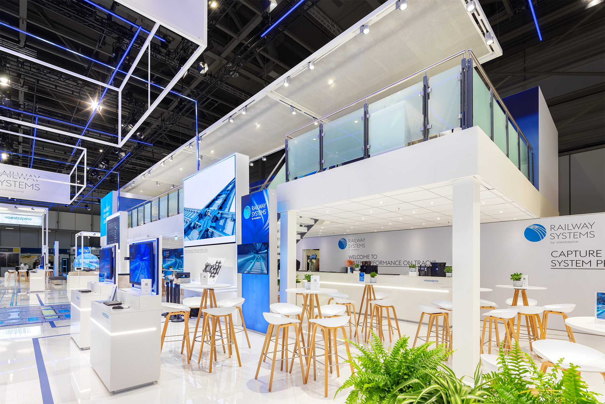 Einladender Empfangsbereich und zweigeschossige Architektur am Messestand von voestalpine Railway Systems auf der InnoTrans 2026.