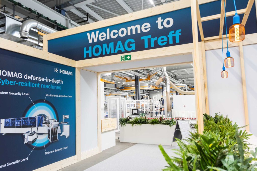 Wooden archway with Welcome to HOMAG Treff sign and pendant lights built by Raumtechnik.