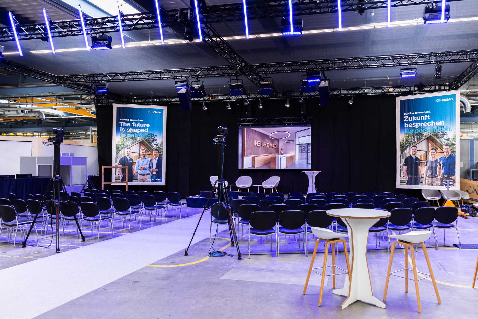 Veranstaltungssaal und Vortragsbühne mit Kamera-Equipment beim HOMAG Treff 2026 von Raumtechnik.
